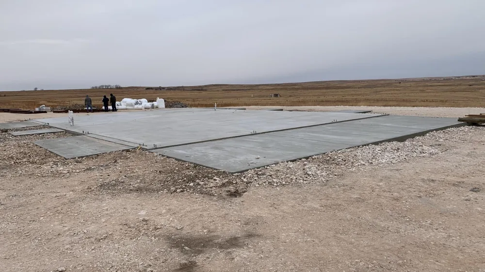 Freshly poured concrete slab for a new home on an open rural lot