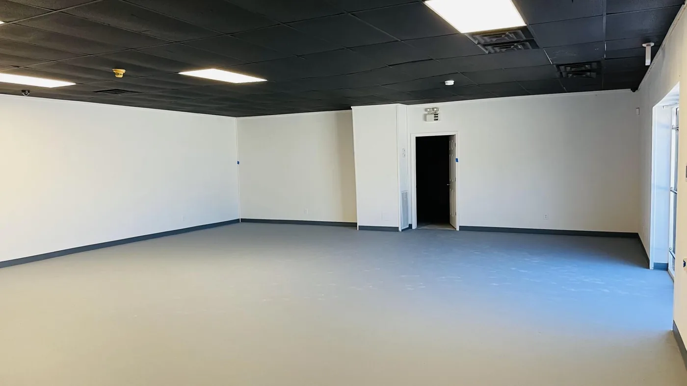 Empty room with smoothly finished, freshly painted drywall and a black open ceiling