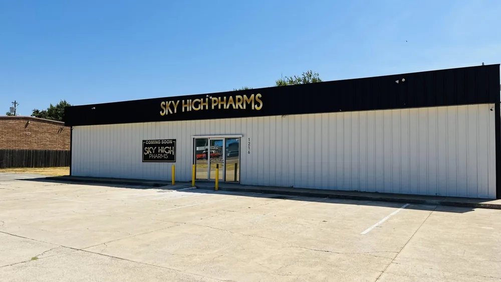 Sky High Pharms retail storefront clad in white metal with a black fascia band