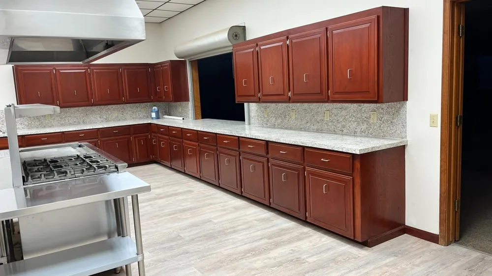 Long run of cherry cabinets with granite countertops along a remodelled kitchen wall