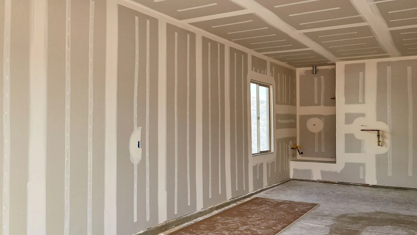 Interior room with newly hung drywall, taped and mudded seams ready for texture